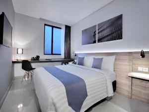 Postel nebo postele na pokoji v ubytování Hotel Neo Gajah Mada Pontianak by ASTON