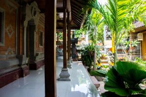a courtyard with palm trees and a building at Shiva House in Ubud