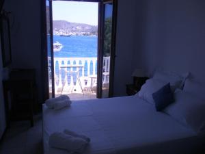 a bedroom with a bed with a view of the ocean at Captain's House Hotel in Skala