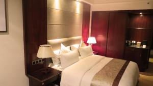 a bedroom with a large bed with a wooden headboard at Rongjiang Hotel in Jieyang