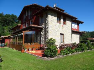 a large house with a patio and a yard at Hotel La Ercina in Intriago