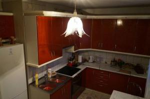 ミエンジズドロイェにあるPokoje u Teresyの赤いキャビネット付きのキッチン、天井から吊るされた照明