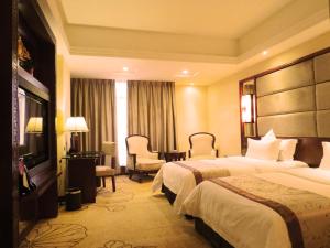 a hotel room with two beds and a television at Rongjiang Hotel in Jieyang