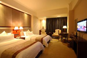 a hotel room with two beds and a flat screen tv at Rongjiang Hotel in Jieyang