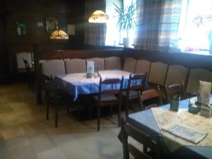 una sala da pranzo con due tavoli, sedie e finestre di Gasthof Schatzl a Grieskirchen