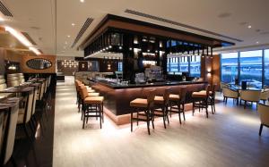 فندق متروبولتان دبي في دبي: مطعم فيه بار فيه كراسي وطاولات