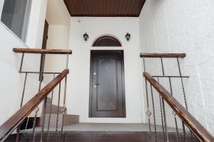 a black door on a white wall with stairs at Family apart in Odesa