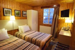 a hotel room with two beds and a window at Christys Palace Hotel in Pedoulas