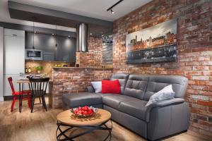 a living room with a couch and a brick wall at Apartament No 118 in Gdańsk