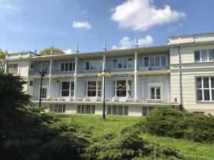 a large white building with a lawn in front of it at Wilson Apartment in Warsaw