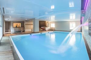 a large swimming pool in a building at Villa Odette in Deauville