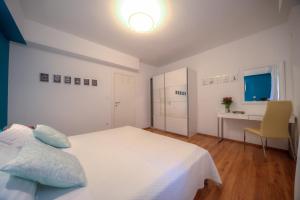 ein weißes Schlafzimmer mit einem Bett und einem Schreibtisch in der Unterkunft Apartment Aleksandra in Pula