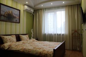 een slaapkamer met een bed en een raam met gordijnen bij Apartment Ecaterina in Chişinău