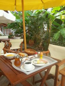 a table with food on it with an umbrella at Oinoi Hotel in Agios Kirykos