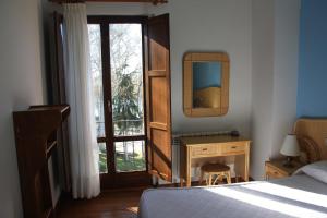 a bedroom with a bed and a mirror and a desk at Bardal de Huerta in Huerta