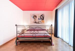 a bedroom with a metal bed in a room with windows at Appartements Hofquartier in Luzern