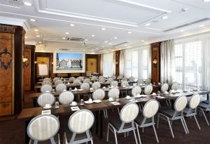 a conference room with tables and chairs and a screen at Van der Valk Hotel Hildesheim in Hildesheim