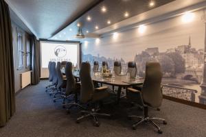 a conference room with a long table and chairs at Van der Valk Hotel Hildesheim in Hildesheim