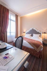 ein Hotelzimmer mit einem Bett und einem Schreibtisch in der Unterkunft Villa 81 in Deauville