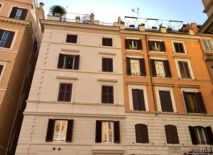 un edificio alto de color blanco con ventanas negras en Apartment Arenula, en Roma