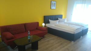 a bedroom with a bed and a couch and a table at Hotel Arheilger Hof in Darmstadt