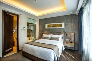 达卡贝斯特韦斯特枫叶酒店的酒店客房设有一张大床和一间浴室。