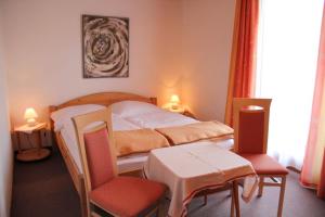 a bedroom with a bed and a table and chairs at Pension Duregger in Faak am See