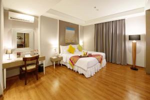 A bed or beds in a room at Pranaya Boutique Hotel