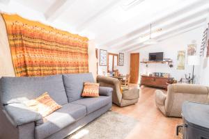 een woonkamer met een bank en 2 stoelen bij Can Mateu in Biniaraix