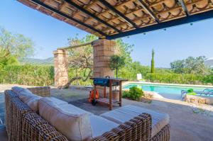 eine Terrasse mit einem Sofa und einem Tisch neben einem Pool in der Unterkunft Son Barbot (Can Robi Nou) in Sant Llorenç des Cardassar