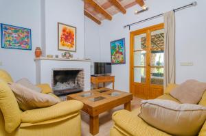 ein Wohnzimmer mit zwei Stühlen und einem Kamin in der Unterkunft Son Barbot (Can Robi Nou) in Sant Llorenç des Cardassar