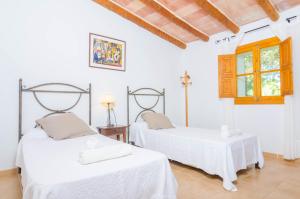 ein weißes Zimmer mit zwei Betten und einem Fenster in der Unterkunft Son Barbot (Can Robi Nou) in Sant Llorenç des Cardassar + 19 Fotos