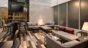 a lobby with couches and chairs and a flat screen tv at Point A Hotel Glasgow in Glasgow