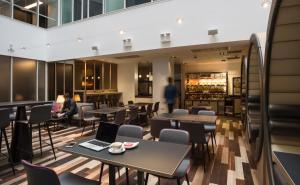 فندق بوينت إيه غلاسغو في غلاسكو: مطعم فيه طاولات وكراسي وناس في الخلف