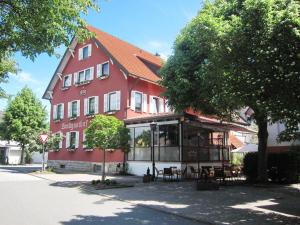 - un grand bâtiment rouge avec un restaurant en face dans l'établissement Landgasthof Krone, à Möckmühl