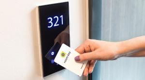 a person unlocking a door with a card in their hand at Point A Hotel London Shoreditch in London