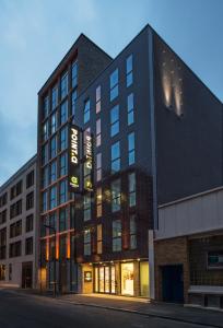 a large black building on a city street at Point A Hotel London Shoreditch in London