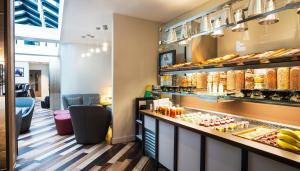 a bakery with a counter with food on it at Point A Hotel London Shoreditch in London