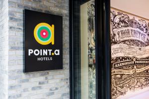 a sign for a pointo hotel on a brick wall at Point A Hotel London Shoreditch in London