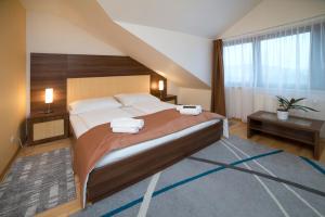 una camera da letto con un grande letto con due asciugamani di Hotel Art a Písek