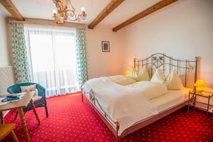 a bedroom with a bed and a table and a window at Appartementhaus Jägerheim in Dorfgastein