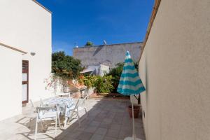 patio ze stołem, krzesłami i parasolem w obiekcie Seaside Apartment w mieście San Vito lo Capo