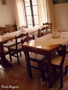 a dining room with wooden tables and chairs and a window at Hotel Angeliki in Ireon