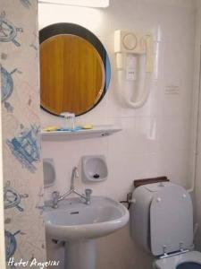 a bathroom with a sink and a toilet and a mirror at Hotel Angeliki in Ireon +29 photos
