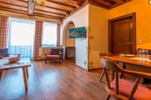 a living room with a table and chairs and windows at Appartementhaus Jägerheim in Dorfgastein