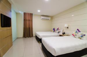 Postel nebo postele na pokoji v ubytování Mornington Hotel Sitiawan