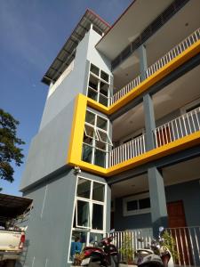 ein weißes und gelbes Haus mit davor geparkt in der Unterkunft Dowrung Place in Phetchaburi