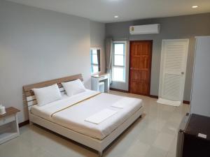 a bedroom with a large white bed in a room at Dowrung Place in Phetchaburi