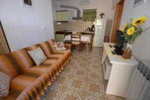a living room with a couch and a kitchen at Apartment Nadica in Punat