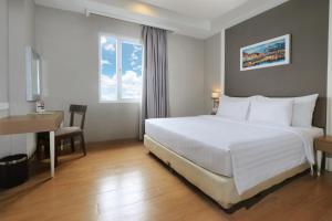 A bed or beds in a room at Pranaya Boutique Hotel